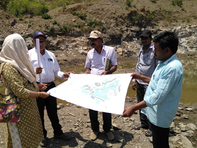 Picture of five people holding a large printed map of local environmental resources in Karnataka, India