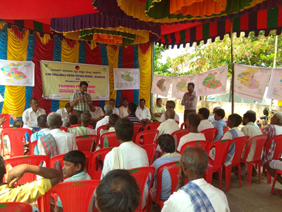 Picture of outdoor covered meeting with experts sharing information with local farmers