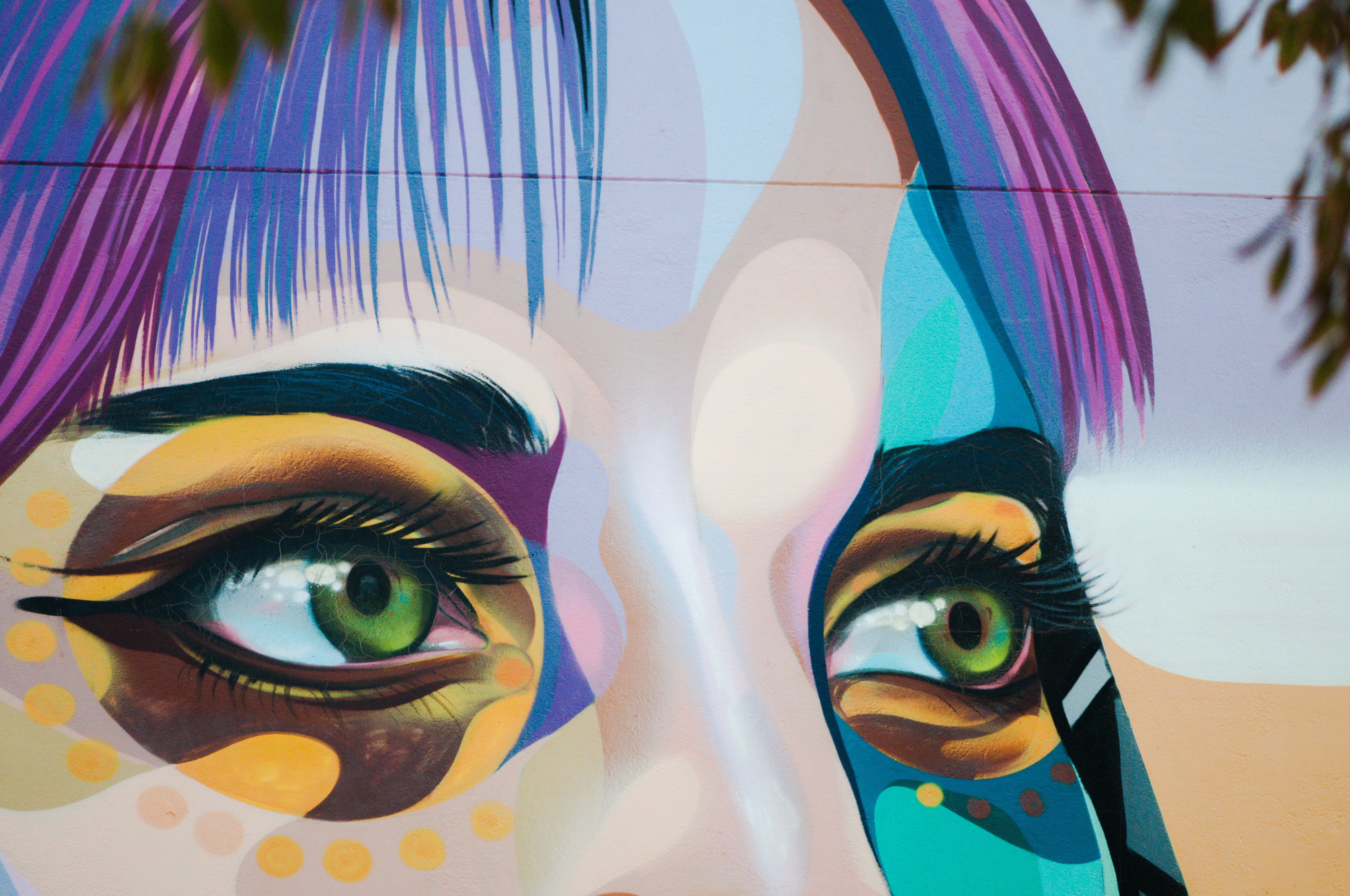 Extract of an artist's graffiti displaying a woman's gaze looking into some distant space. painted with bright captivating colours. 