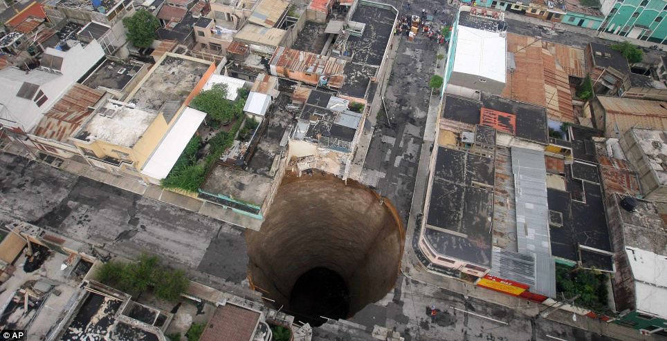 Aerial picture of massive, round sink hole in the middle of a neighbourhood in Guatemalan city